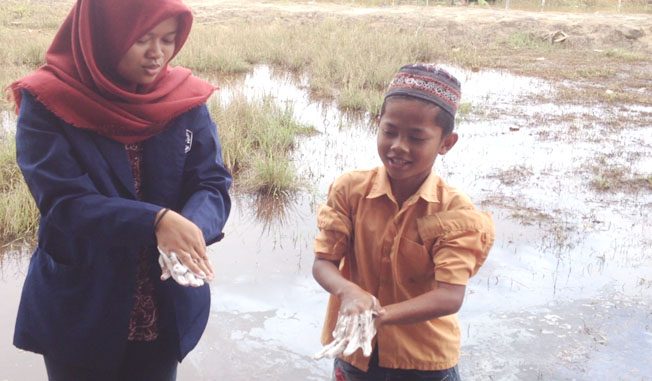 Mahasiswa TL Untan mengajarkan cara mencuci tangan yang baik dan benar kepada siswa MI Desa Teluk Empening